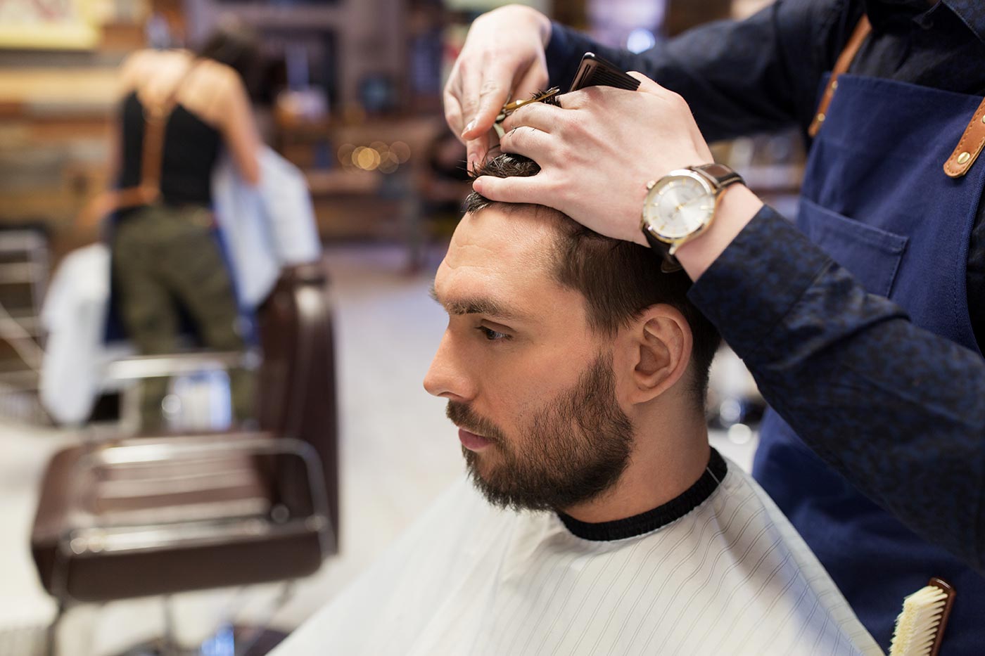 man-and-barber-cutting-hair-at-barbershop-PPLF57R